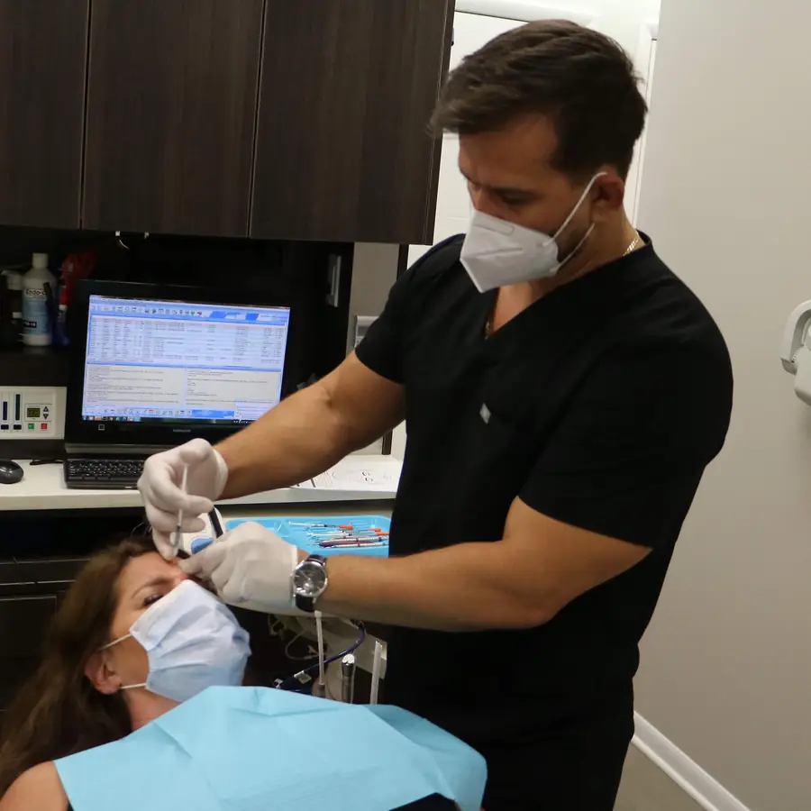 Dr. Thanasi Loukas performing a Botox injection in the forehead area at Loukas Dentistry in Park Ridge, IL
